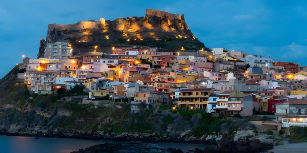 a village on a mountain at night at Appartamenti Flora in Castelsardo