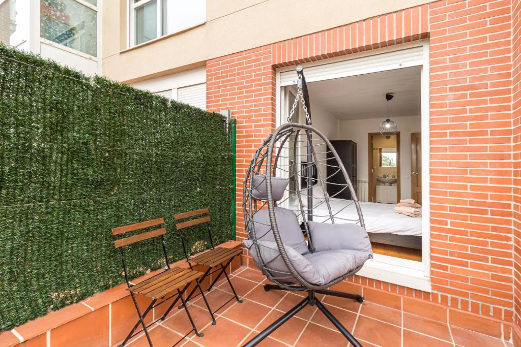 a swing on a patio with a bed in a window at Surf House Gama in Gama