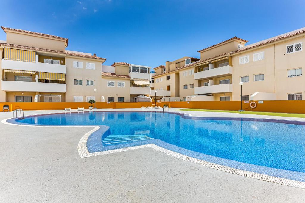 a swimming pool in front of a apartment complex at La Octava Isla in Puertito de Güímar
