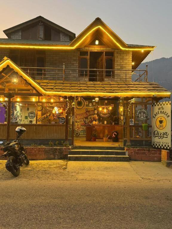 a house with a motorcycle parked in front of it at Hikers & Bikers in Haripūr