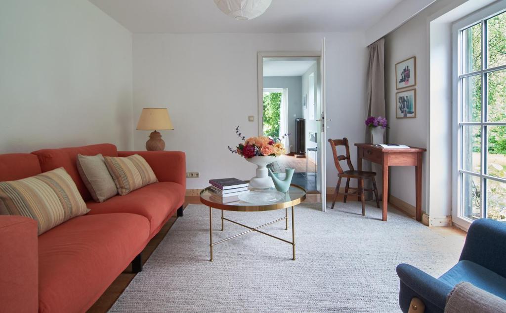 a living room with a red couch and a table at Künstlerwohnung im Naturpark in Meezen