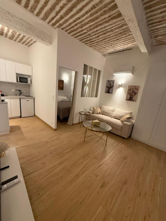a living room with a couch and a table at Très Grand studio neuf 50 m du port Lovely charrons 2 in Saint-Tropez