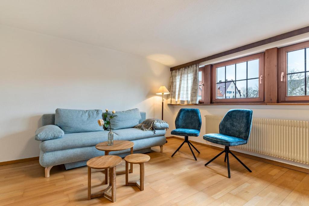 a living room with a blue couch and two chairs at Fewo Straub in Freudenstadt