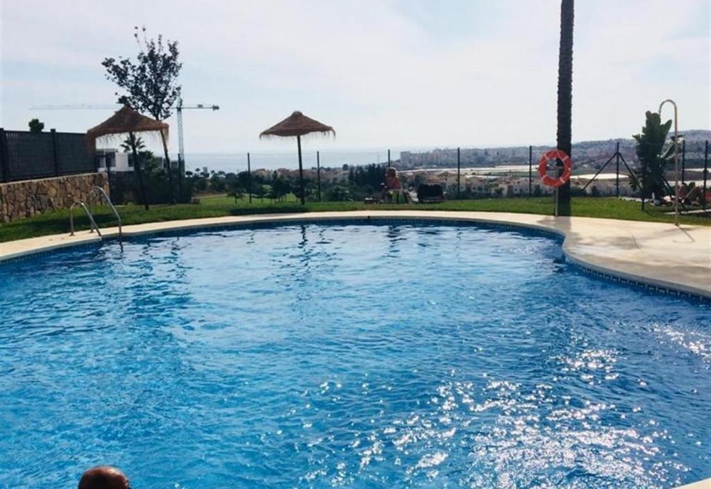 a large swimming pool with blue water at Lux Apartm Beauvivir in Torre del Mar