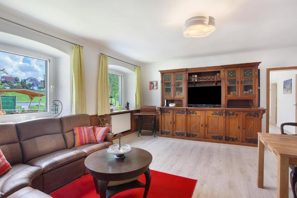 a living room with a couch and a tv at Ferienwohnung auf dem Ennerthof in Arnsberg