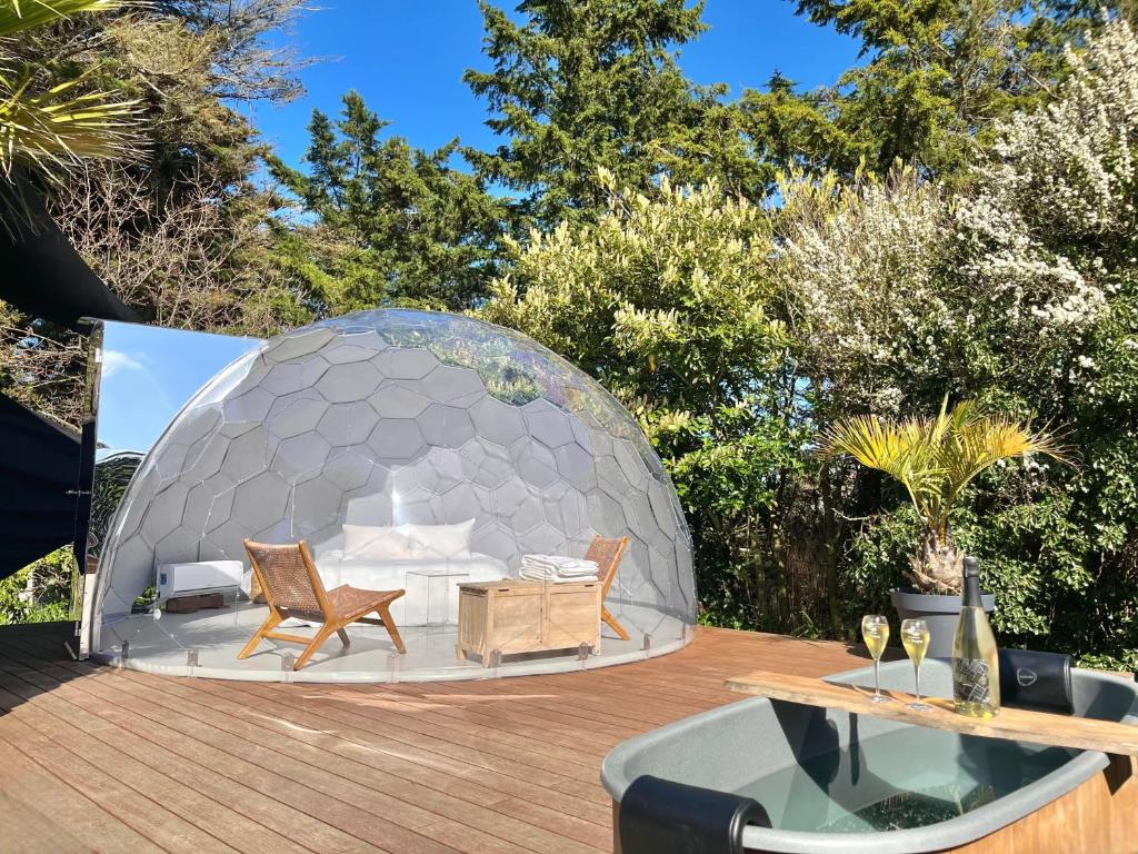 a dome house on a deck with chairs and a table at La Saint Pabu'lle in Pléneuf-Val-André