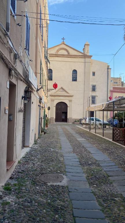 an empty street in front of a building with a red balloon at Casa Rica in Alghero