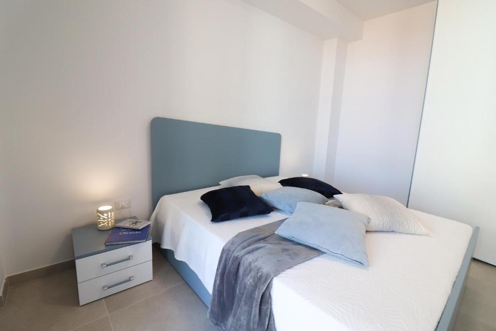 a bedroom with a large white bed and a night stand at Holiday home Galatea a Otranto in Otranto