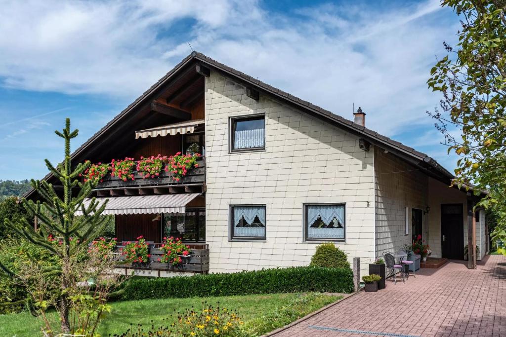 a white house with flowers on the balcony at Haus Berger in Wehr