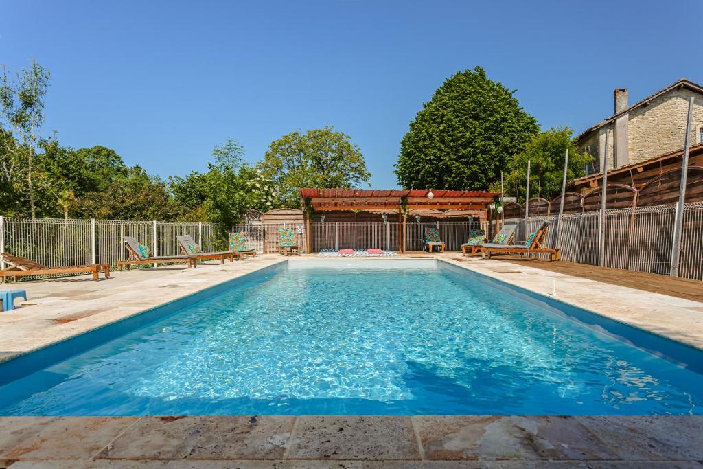 a large swimming pool with blue water at Chambre d'hote Saphir in Genouillé