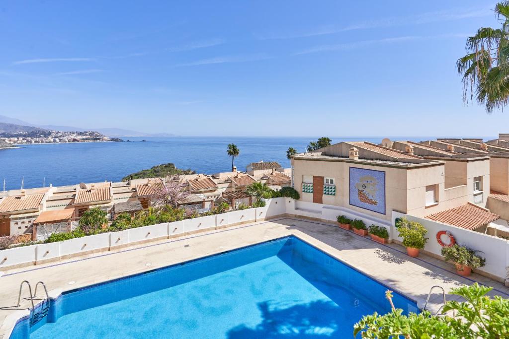 a swimming pool on the roof of a house with the ocean at Las Lomas de Marina del Este in Almuñécar
