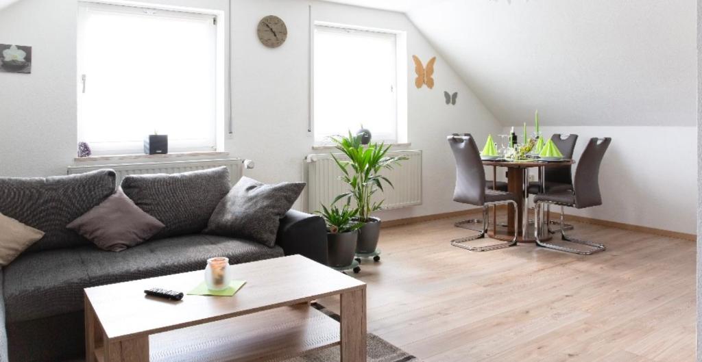 a living room with a couch and a table at Ferienwohnung Am Palmengarten in Marktbergel