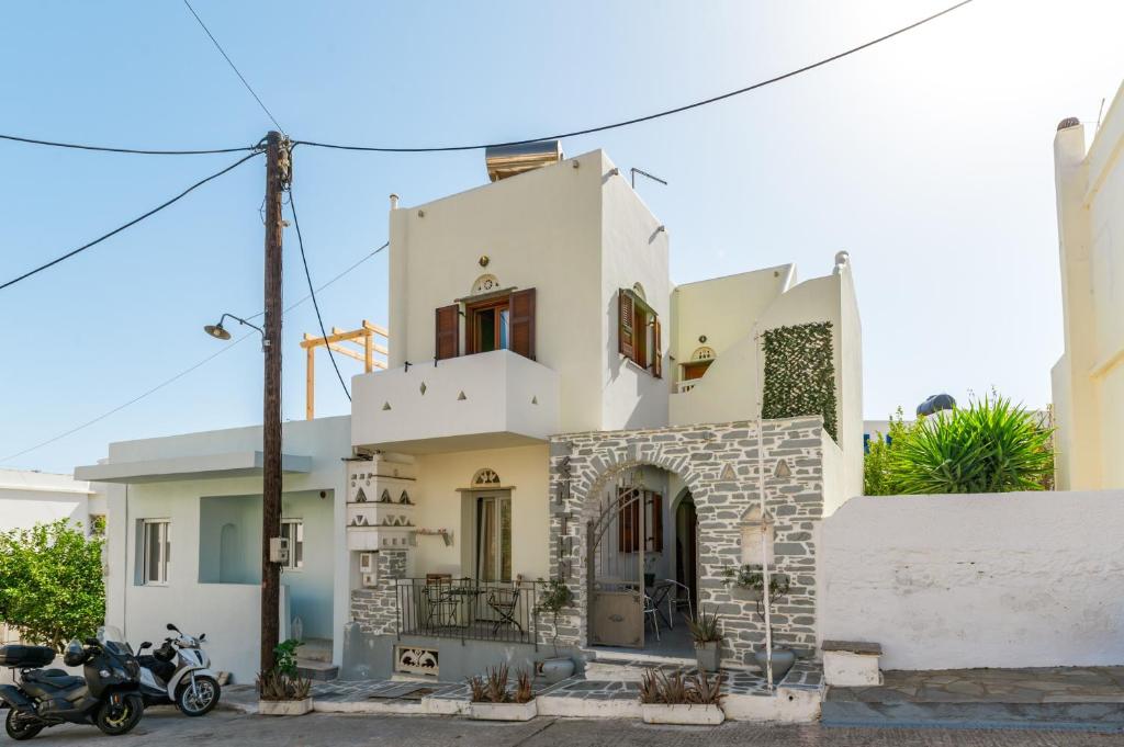 a white house with a motorcycle parked in front of it at En Tino 4 in Tinos