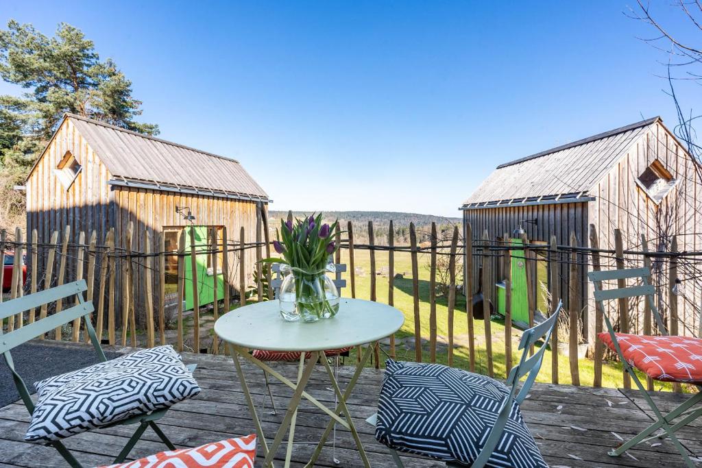 eine Terrasse mit Tisch und Stühlen und einem Zaun in der Unterkunft Tiny Houses der Dorfscheune in Bieselberg