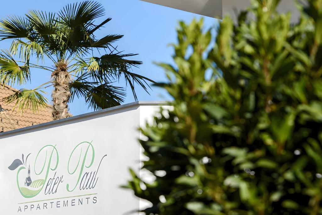 a sign for the golf ball apartments with a palm tree at Peter Paul Terrasseapp Burgenblick in Appiano sulla Strada del Vino