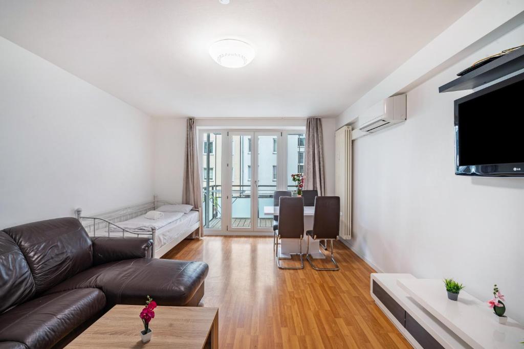 a living room with a couch and a tv at Aldars Urban Suite No.10 in Munich