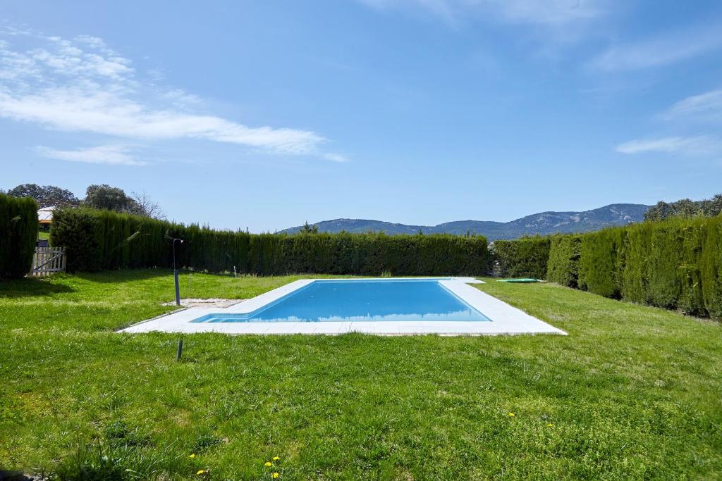 a swimming pool in the middle of a grass field at La Aldeilla in Aldeaquemada