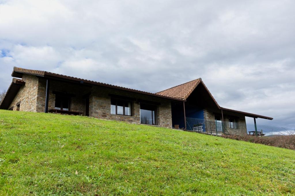 ein Steinhaus auf einem Hügel mit grasbewachsenem Hang in der Unterkunft Amama in Karrantza