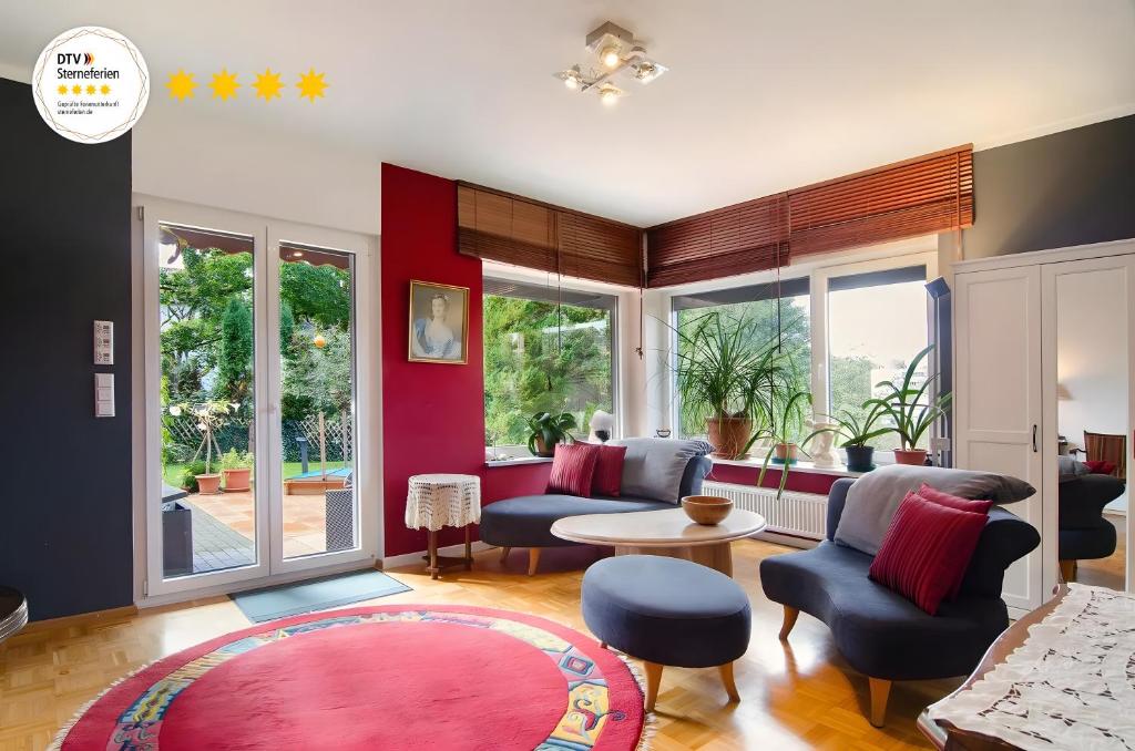 a living room with blue chairs and a red wall at Ferienwohnung Refugium Schönenberg in Sigmaringen