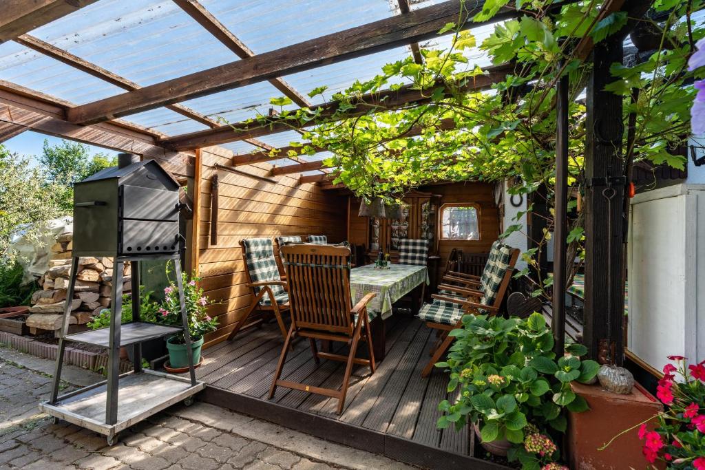 a patio with a pergola and a table and chairs at Gästehaus Gross in Neustadt an der Weinstraße
