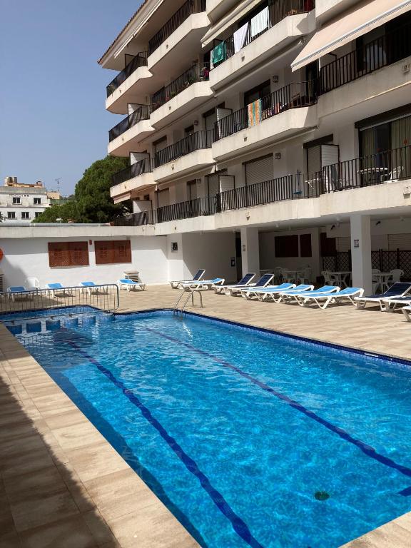 a large swimming pool in front of a building at Sunny apartment with pool in Tossa de Mar