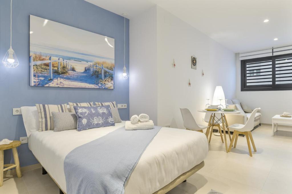 a bedroom with a large white bed and a table at Apartamento Tarifa Dream B 08 in Tarifa