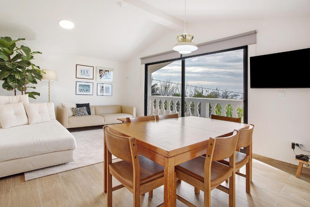 a living room with a table and a couch at Casa Do Lenhador in Canhas