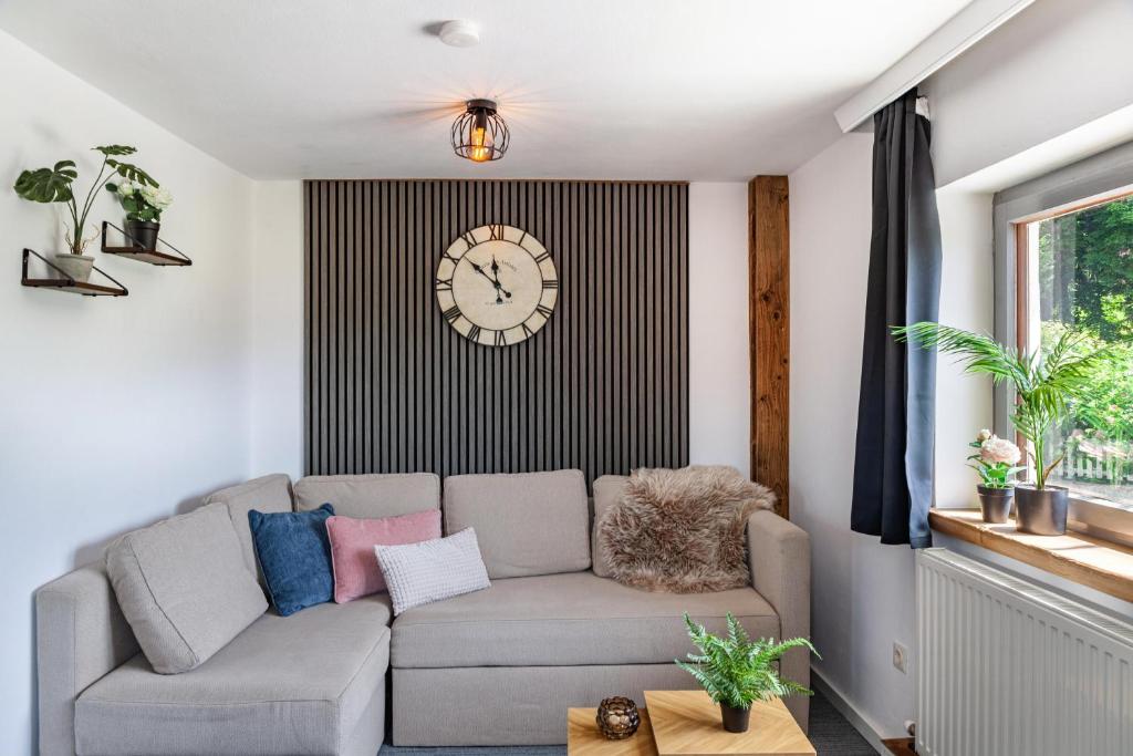 a living room with a couch and a clock on the wall at Feichtenhäusl app 1 in Westendorf