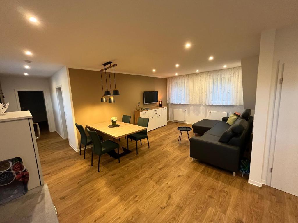 ein Wohnzimmer mit Sofa und einem Tisch mit Stühlen in der Unterkunft Seeterrasse in Versmold