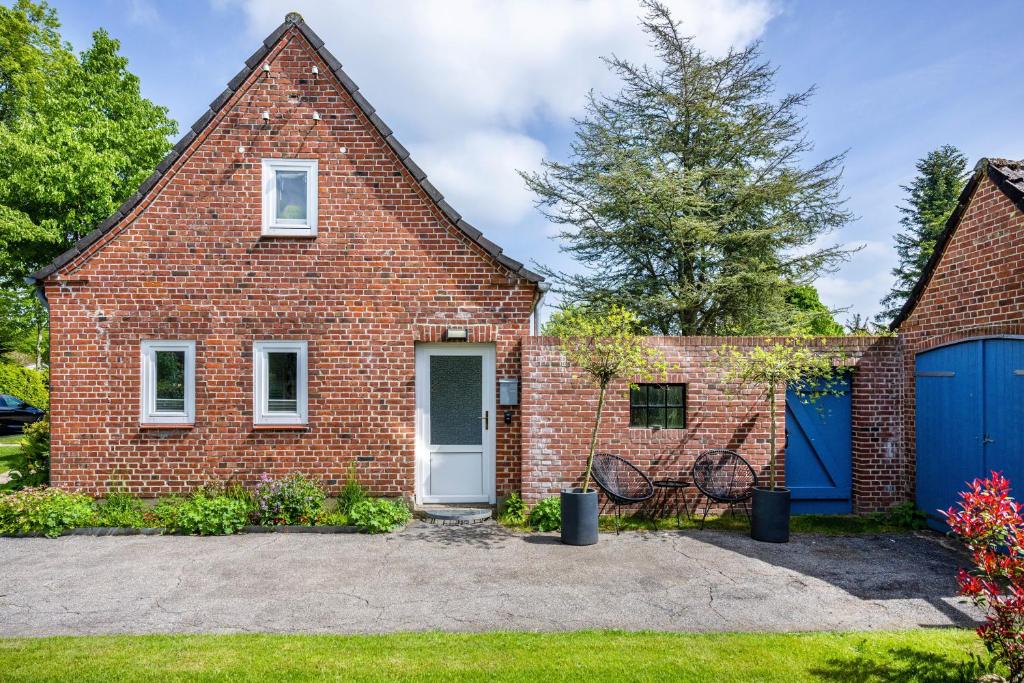 a brick house with a blue garage at Ferienwohnung Halunder in Leck