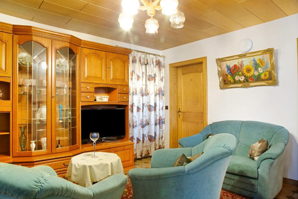 a living room with two chairs and a tv at Ferienwohnungen Landhaus Strell in Bad Griesbach
