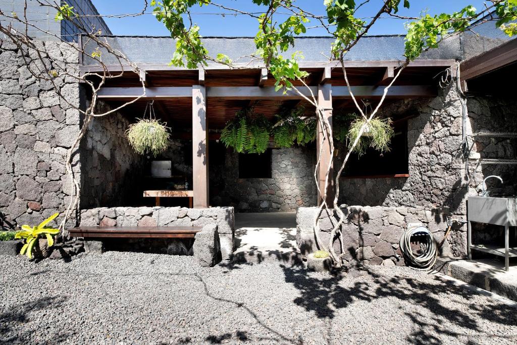 a stone house with a bench in front of it at Finca El Refugio in Teguise