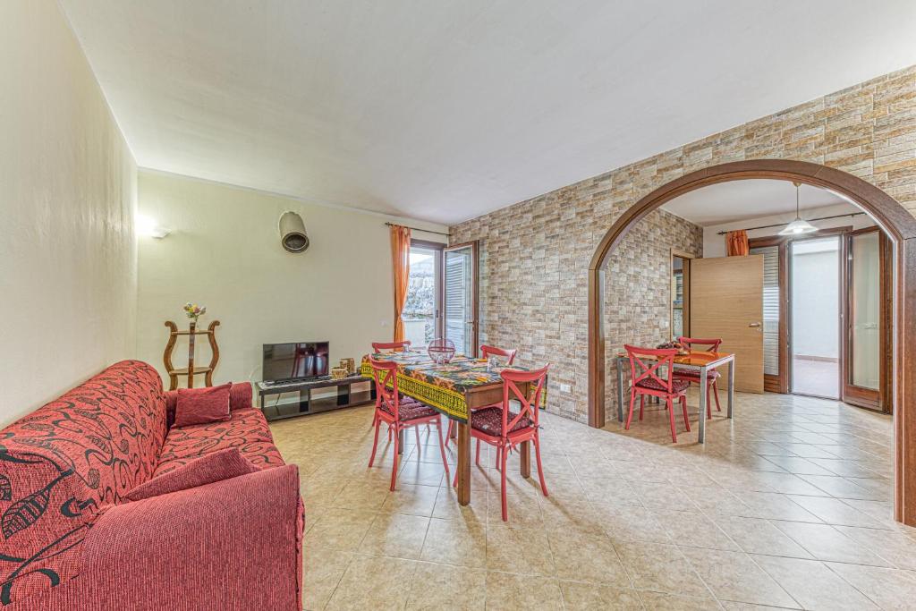 a living room with a red couch and a table and chairs at Casa Castro Vista Grotta in Castro di Lecce