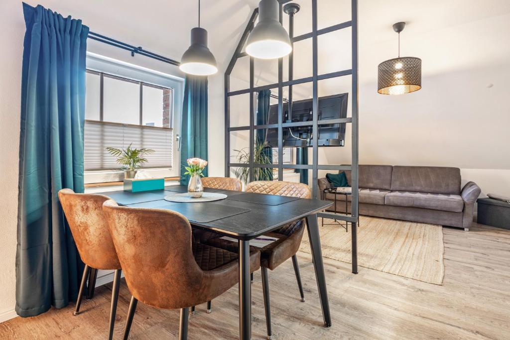 a dining room with a table and chairs and a couch at Cosy Apartment In Soltau in Soltau