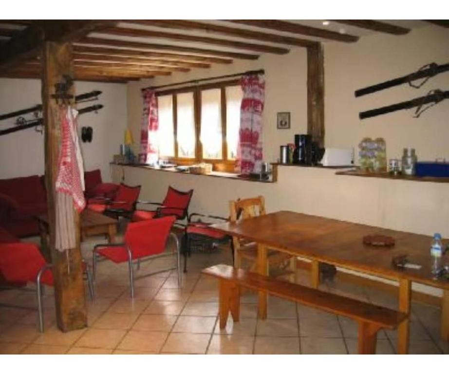 a dining room with red chairs and a wooden table at Chalet - Les 3 vallées in La Combe