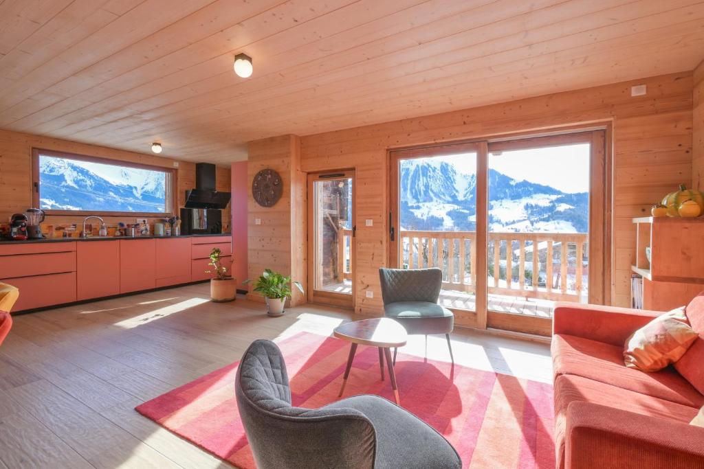 a kitchen and living room with a view of mountains at Appartement dans le Chalet l'Albert in Manigod