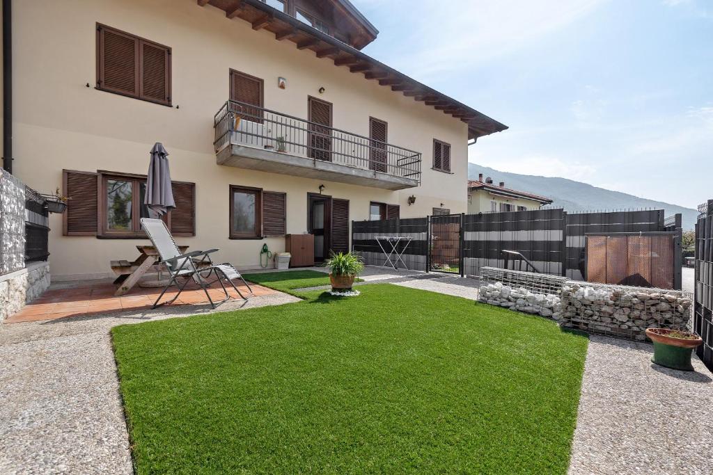 a patio with a lawn in front of a house at Casa Zoe in Arco