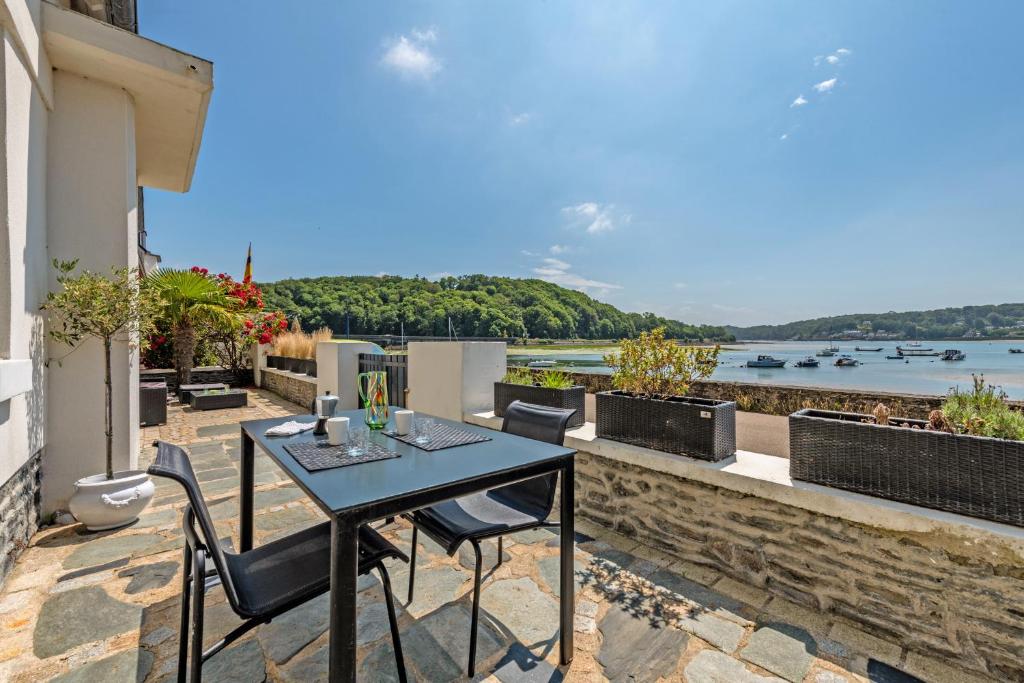 a table and chairs on a balcony with a view of the water at Évasion marine face à la mer in Plouézocʼh