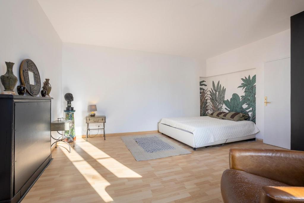 a living room with a bed and a couch at L'Eclose Chambre Kergoz in Le Guilvinec