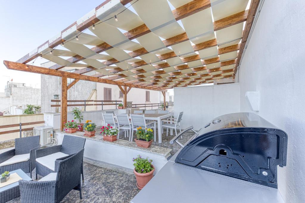 a patio with a table and chairs and a grill at Dimore degli innamorati in Presicce