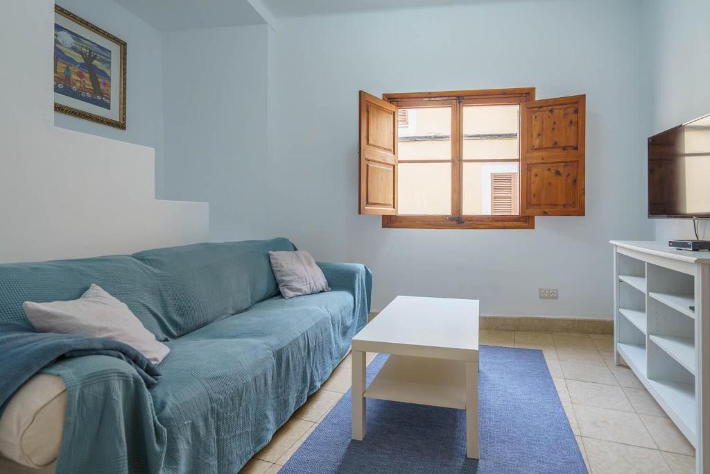 a living room with a blue couch and a table at Maca Green, Adosado Centro Campanet in Campanet