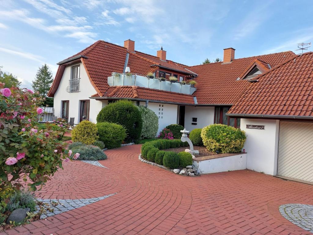 a house with a red roof and a brick driveway at Ferienwohnung Evi Opp - Harmonie in Brodersdorf
