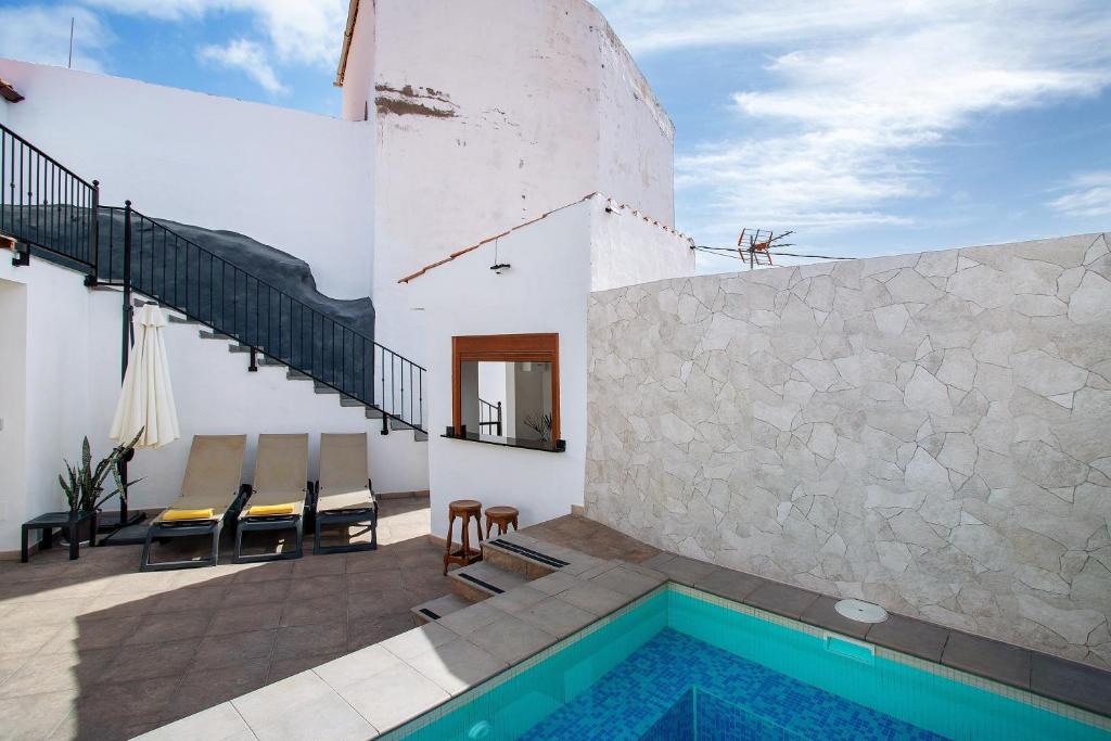 a house with a swimming pool next to a building at Casa Celestina in Temisas