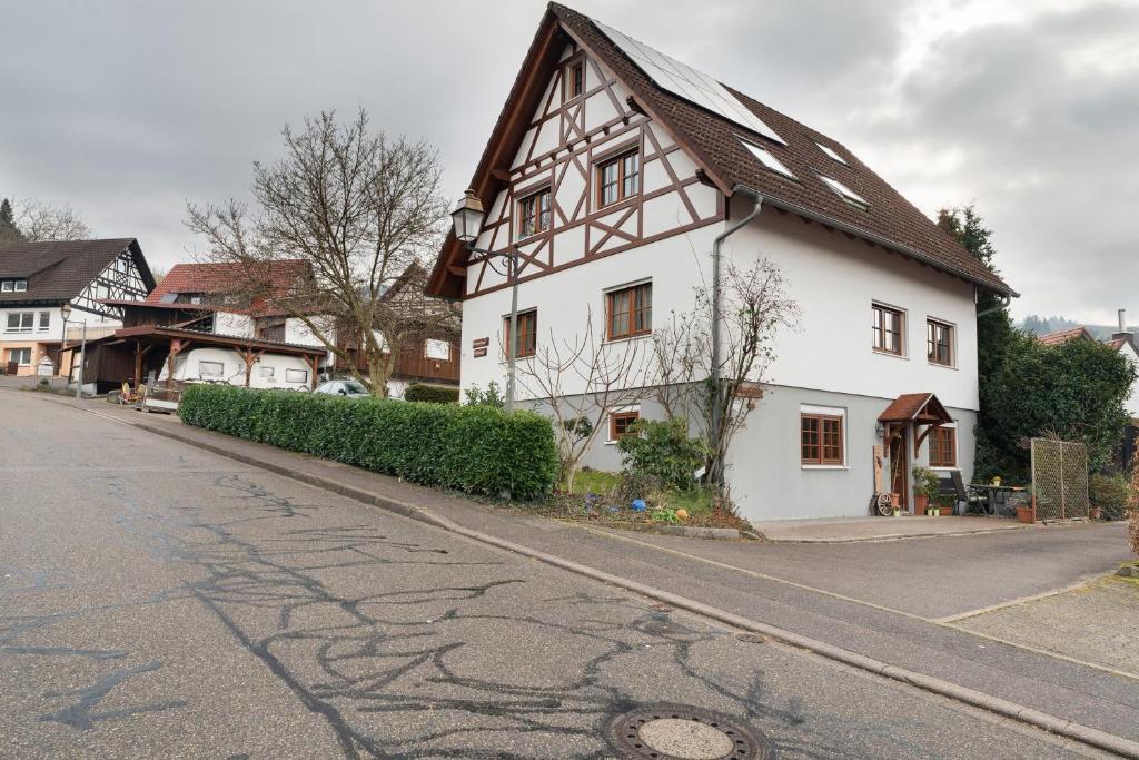 a white house with a brown roof on a street at Ferienwohnung Heike Schreiber in Sasbachwalden