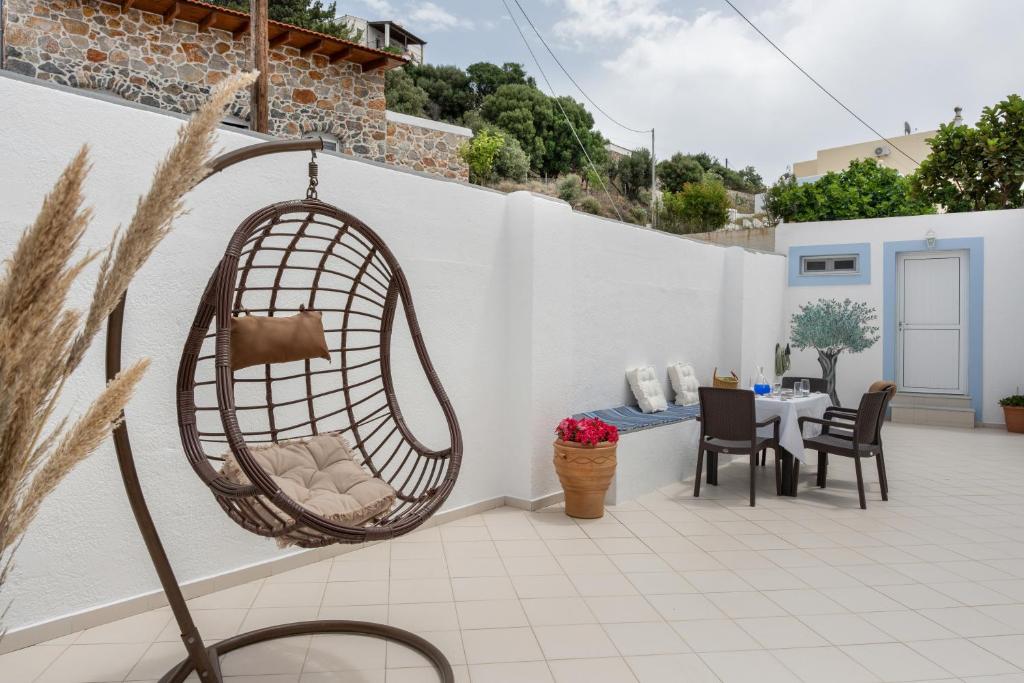 a swing hanging from a wall on a patio at Niki's Studios Kalymnos in Kalymnos