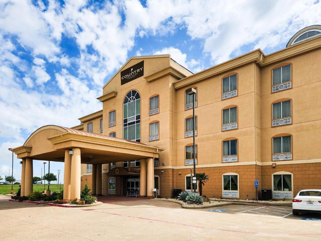 a hotel building with a car parked in front of it at Country Inn & Suites by Radisson, Terrell in Terrell
