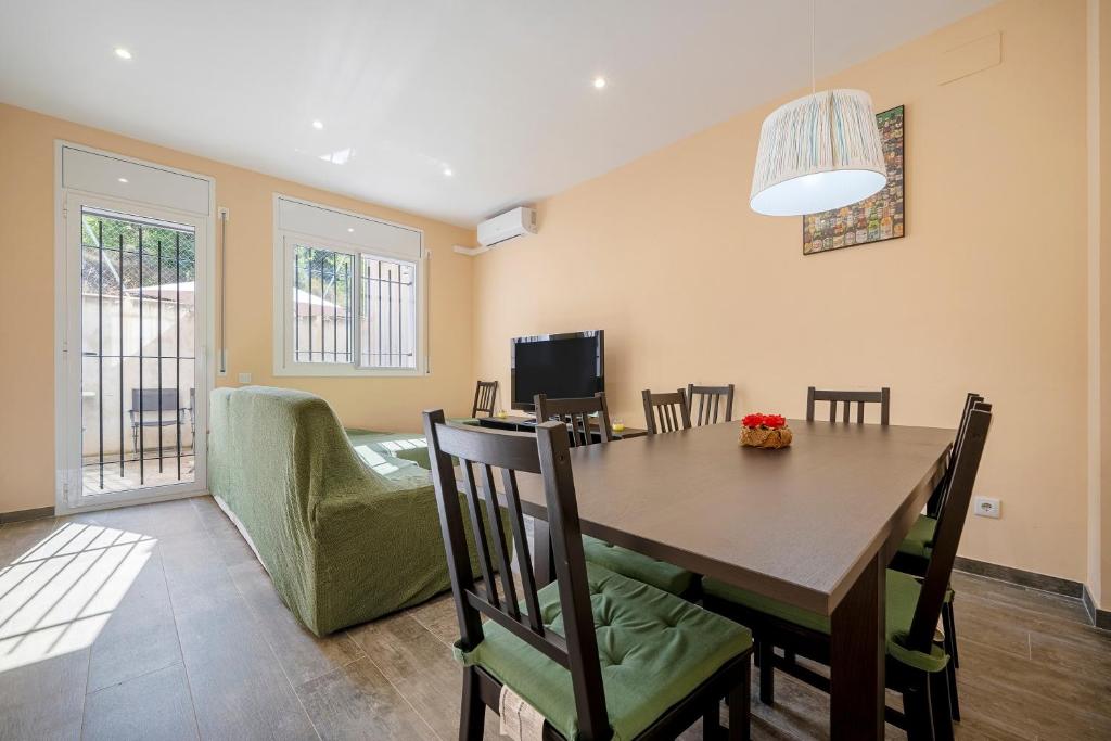 a dining room with a table and a green chair at Casa Lluma in Aldover