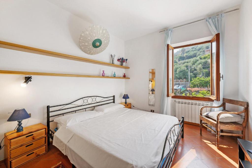 a bedroom with a bed and a window and a chair at Luca Via Gavazzo 18 in Bonassola