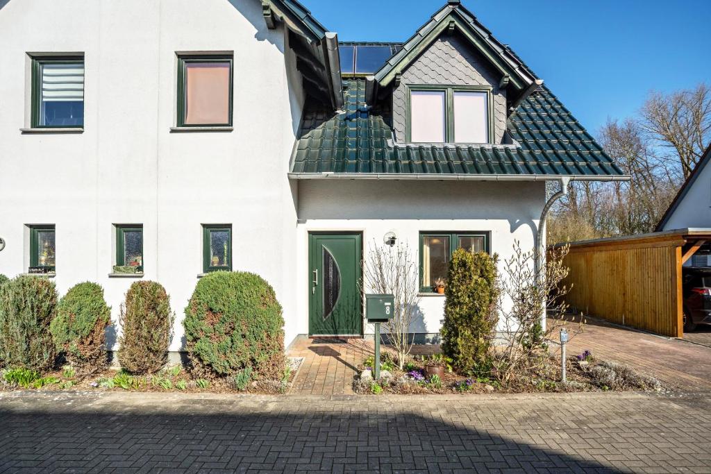 a white house with a green door at Reinhards Ferienwohnung in Greifswald