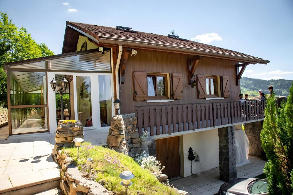 a house with a balcony and a patio at Chalet Bellevue Vue exceptionnelle in Basse-sur-le-Rupt